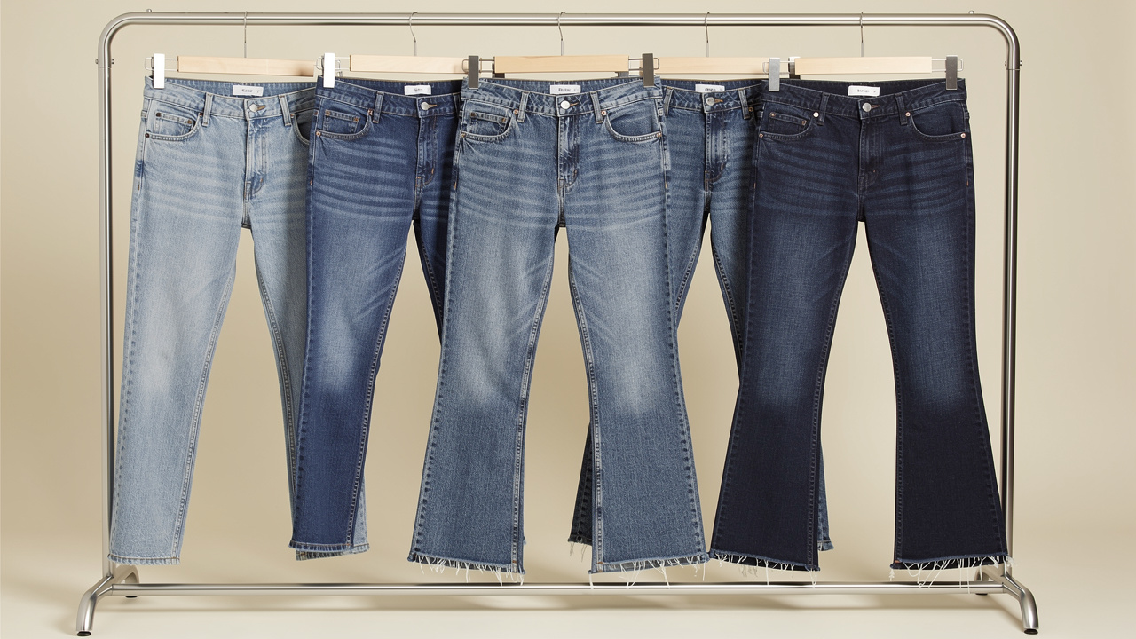 Cinq pantalons jeans femme présentés sur un portant, avec des coupes droite, slim, mom, flare et bootcut, ainsi que différentes hauteurs de taille et longueurs de jambes.